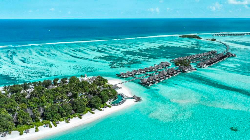 Aerial view of Maldives surfing paradise near Four Seasons Kuda Huraa, with reef breaks and clear turquoise water